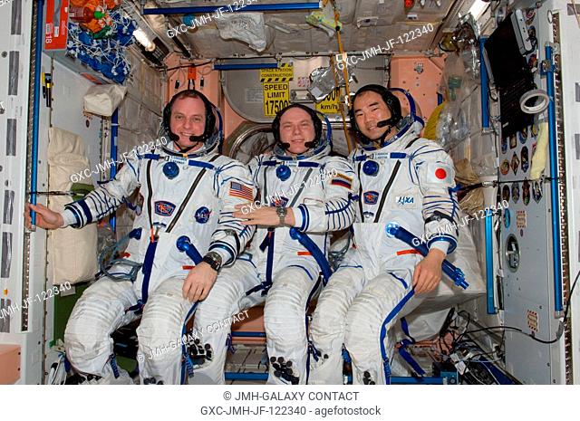 Attired in their Russian Sokol launch and entry suits, Russian cosmonaut Oleg Kotov (center), Expedition 23 commander; along with NASA astronaut T.J