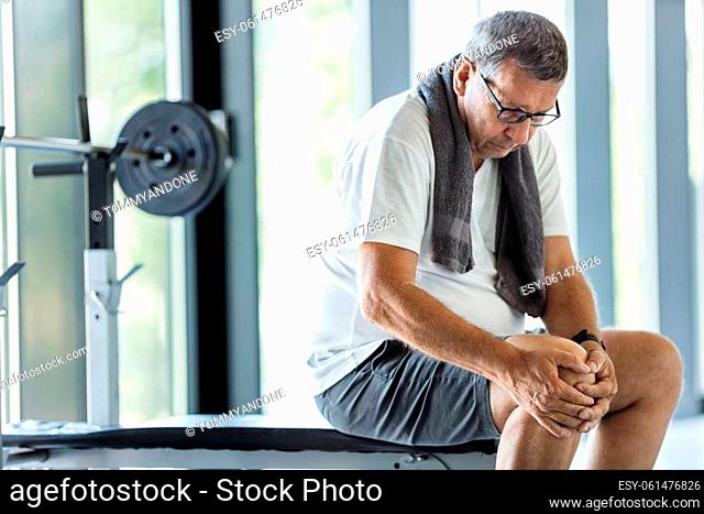 Active senior man in gym with knee injury