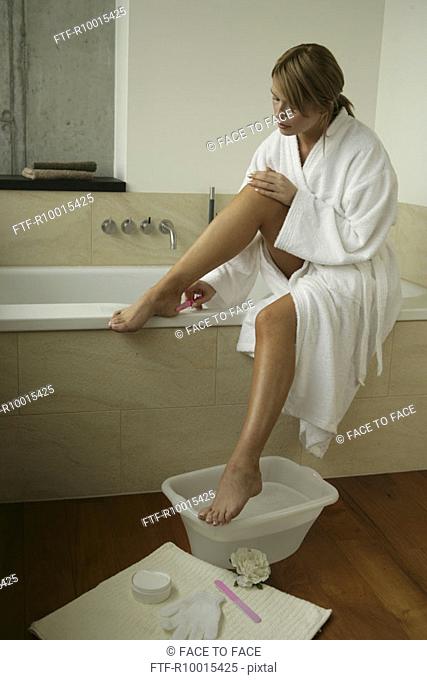 A blonde woman cleaning her foot