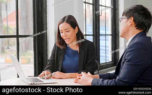 Two business people talk project strategy at office, Businessman and businesswoman Businessman discuss project planning with laptop computer