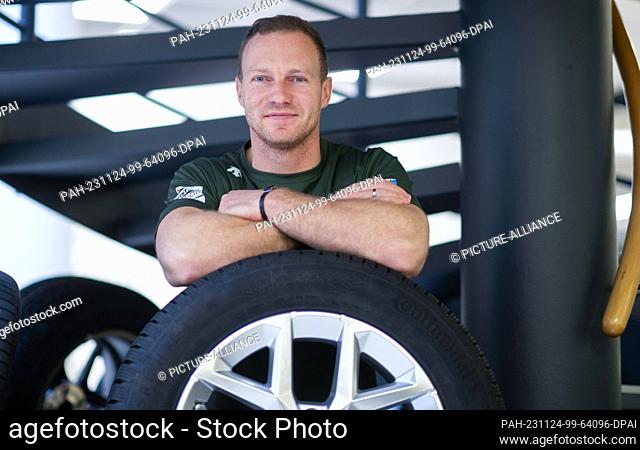 24 November 2023, Saxony, Dresden: Bobsleigh pilot Francesco Friedrich stands at a tire on the sidelines of the press conference of the German Bobsleigh and...