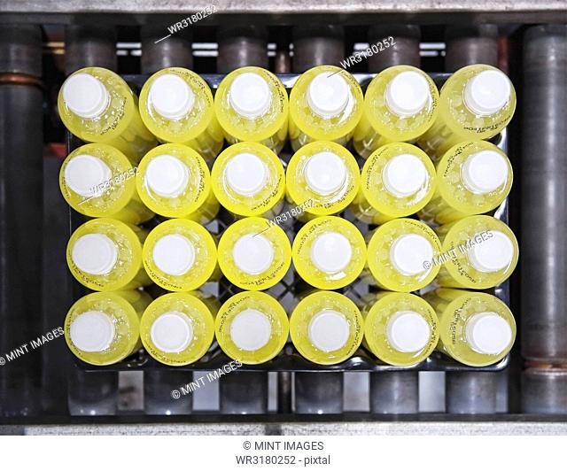 Closeup of bottles with lemon flavoured water on a bottling plant production line