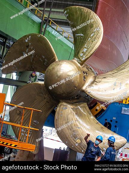 14 July 2021, Mecklenburg-Western Pomerania, Wismar: Shipbuilders prepare one of a total of three azipods for installation under the cruise ship ""Global...