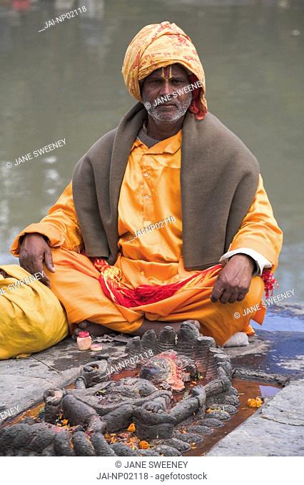 Nepal, Kathmandu, Pashupatinath Temple, Shivaratri festival, Sadhu Holy man sits on the banks of the Bagmati river
