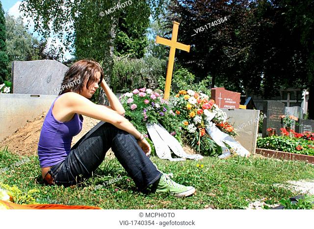 Young woman mourns on a fresh grave - 01/01/2009
