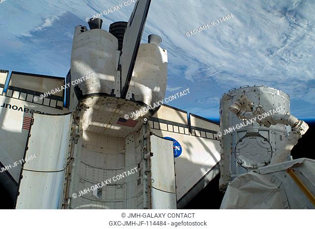 In the grasp of the station's Canadarm2, the Tranquility module is transferred from its stowage position in space shuttle Endeavour's (STS-130) payload bay to...