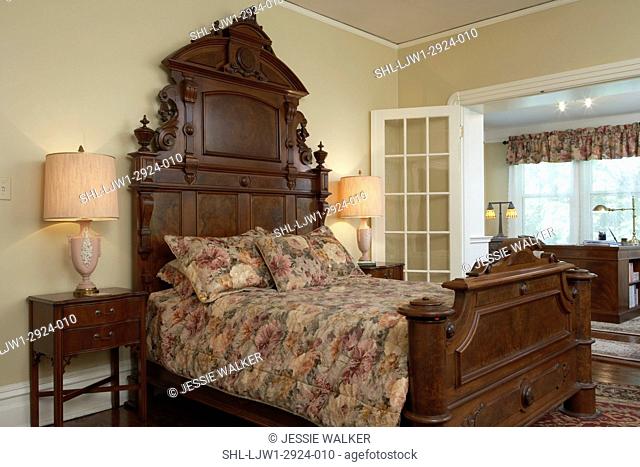 BEDROOM: Walnut Victorian carved bed with 10ft high headboard, neutral floral bedding, matching Alladin bedside lamps, french doors lead to a home office area