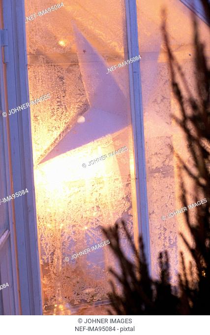 Close up of frozen window with Christmas decorations