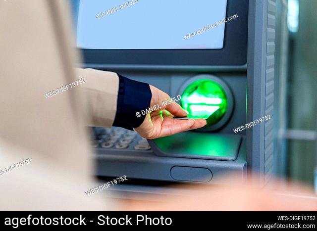 Hand of businesswoman inserting credit card in ATM
