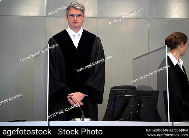 04 May 2020, North Rhine-Westphalia, Duesseldorf: Mario Plein, presiding judge, stands between panes of glass at the judge's table