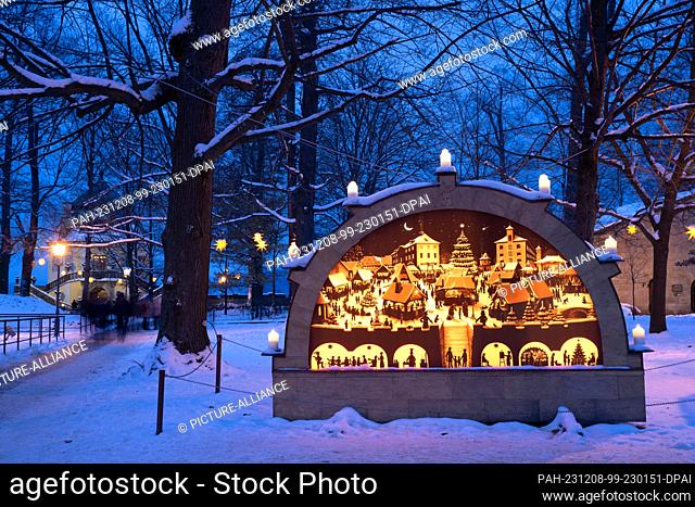 08 December 2023, Saxony, Königstein: The candle arch at the Christmas market at Königstein Fortress is brightly lit. The historic and romantic Christmas market...
