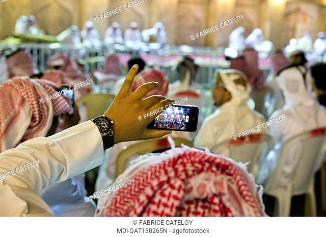 Qatar - Doha - Souq Waqif - Qatari recording an outdoor concert with mobile phones