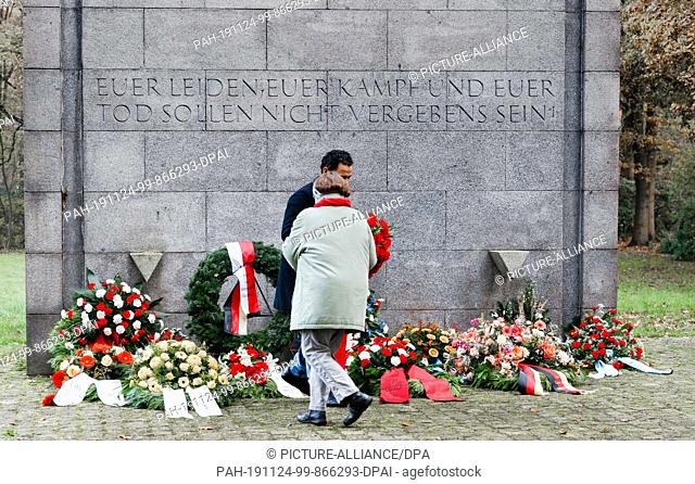17 November 2019, Hamburg: Two members of the civil staff lay down a wreath at the International Memorial on the grounds of the Neuengamme Memorial on Memorial...