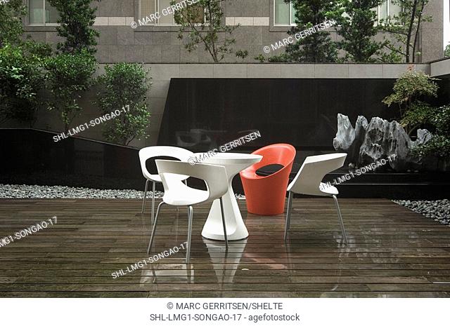 Modern deck furniture in rain on wooden deck