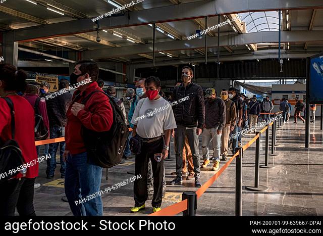 01 July 2020, Mexico, Mexiko-Stadt: People wearing face masks are queuing in a subway station in the middle of the corona pandemic