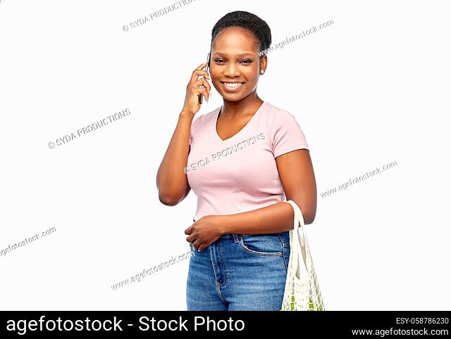 woman with food in net bag calling on smartphone