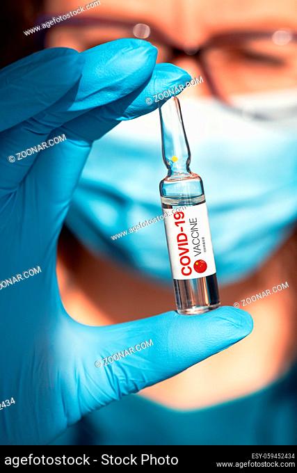 Coronavirus China-developed vaccine concept: vaccine with China flag in doctor hand with blue protective gloves