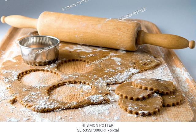 Raw cookies with dough and rolling pin