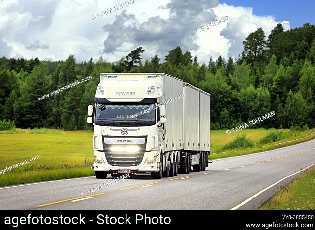 White DAF XF freight transport truck Malinen with bright LED lights on the road on a day of summer. Salo, Finland. July 24, 2020