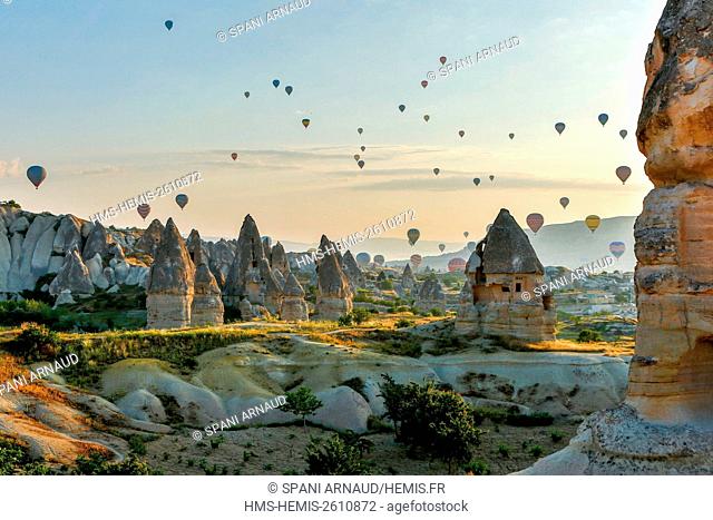 Turkey, Nevsehir, Cappadocia, Goreme, listed as World Heritage by UNESCO, Goreme National Park, overflight of Cappadocia with multicolored balloons (aerial...