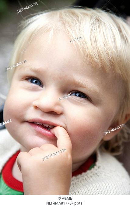 Girl with finger in mouth, smiling