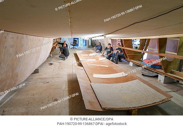 16 July 2019, Brandenburg, Kienitz-Nord: The shell of a catamaran can be seen in a hall. Some people dream of a trip around the world