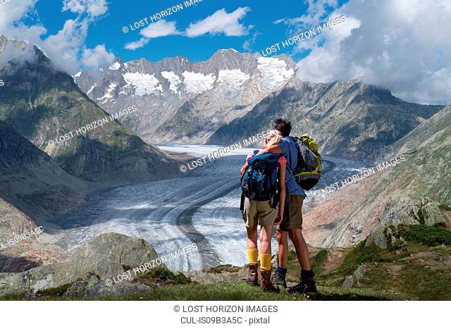 Hiking couple looking out over Aletsch Glacier, Canton Wallis, Switzerland
