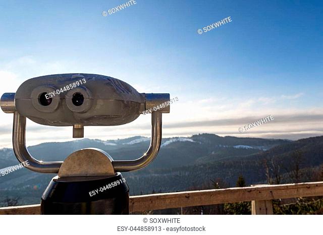 Binoculars looking out winter Carpathian mountains. Bukovel, Ukraine