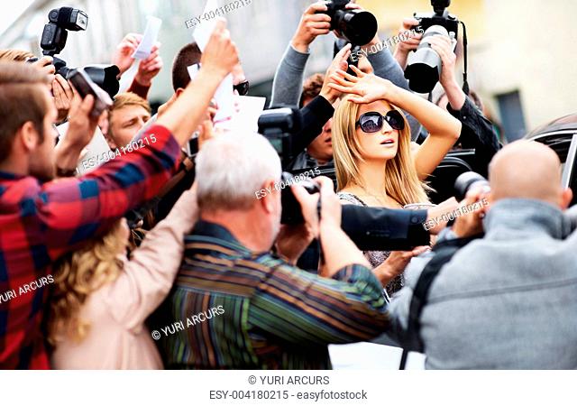 Beautiful celebrity trying to get away from the paparazzi and reporters