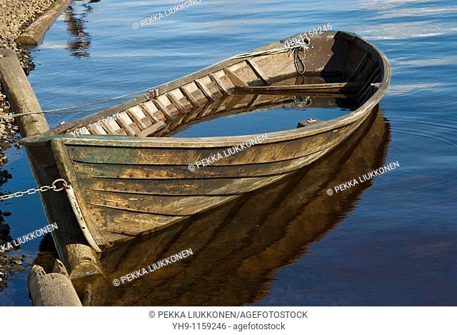 Wooden boat soaking. Oulujoki river, Oulu province, Finland