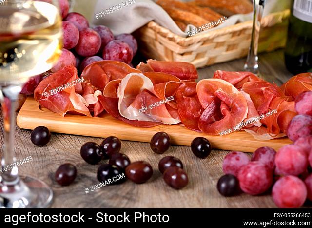 Antipasto. Wine set  snack sun-dried ham jamon with grapes and olives