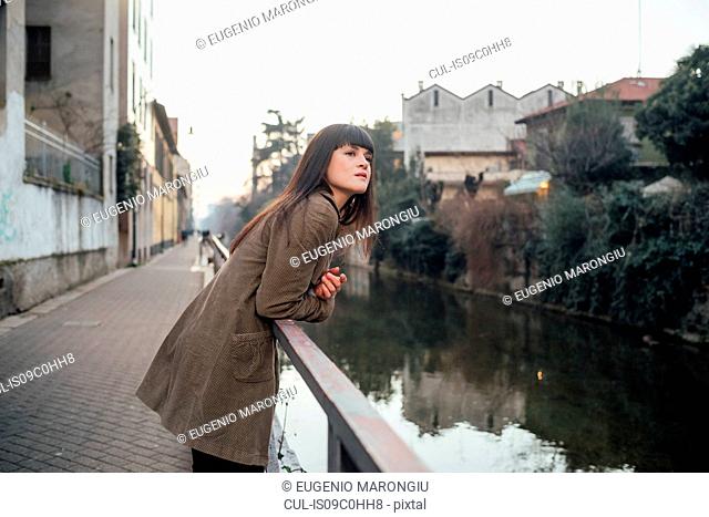 Woman relaxing by river, Milano, Lombardia, Italy
