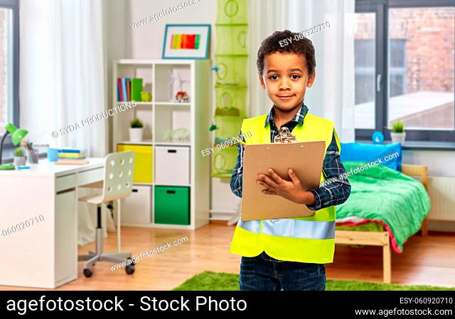 little boy in safety vest with clipboard at home