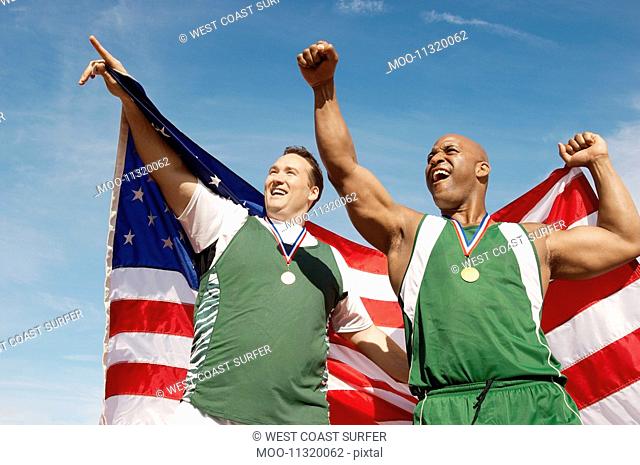 Male athletes celebrating with medals and American flag