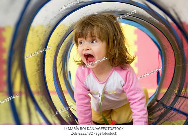 19 months old baby girl playing inside a tunnel