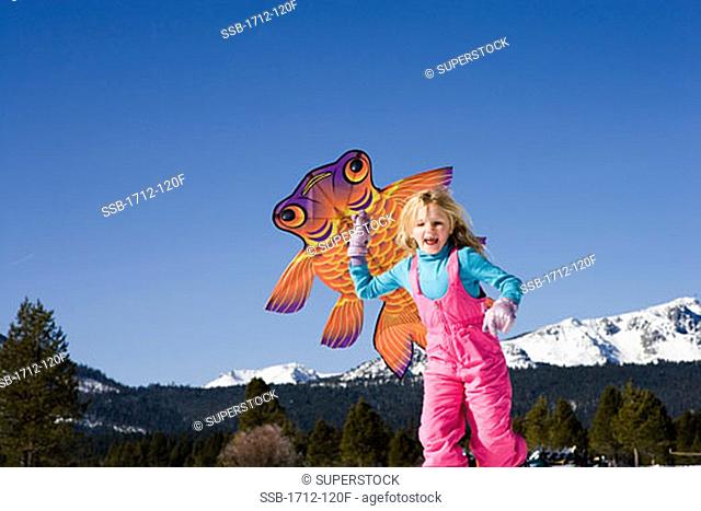 Low angle view of a girl running with a kite