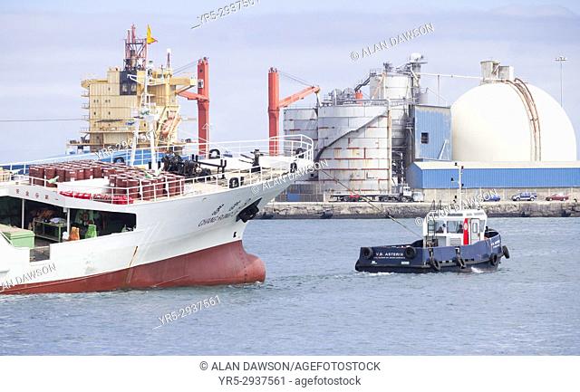 Listing Chinese fishing trawler being towed by tug boat out of Las Palmas port on Gran Canaria, Canary Islands, Spain