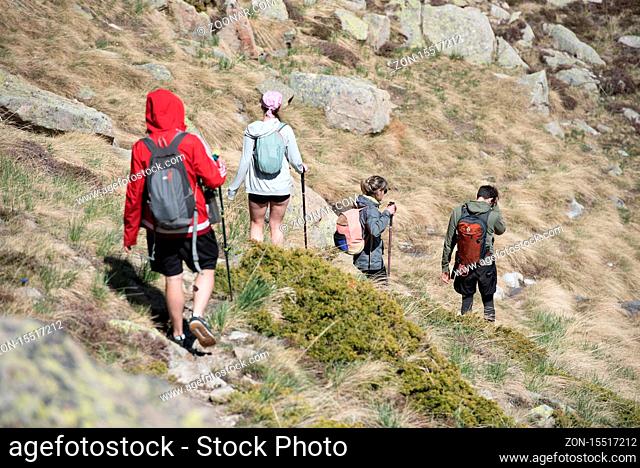 Grau Roig, Andorra : May 20 2020 : Four young hikers are Lake in the circuit of Lake Pessons Grau Roig, Andorra in spring