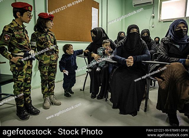 17 November 2022, Afghanistan, Kabul: Two boys dressed as soldiers look at a woman devoted to her children in a classroom at a police barracks where women are...
