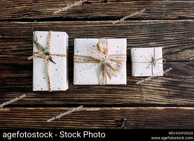 Christmas gifts wrapped in white paper on table