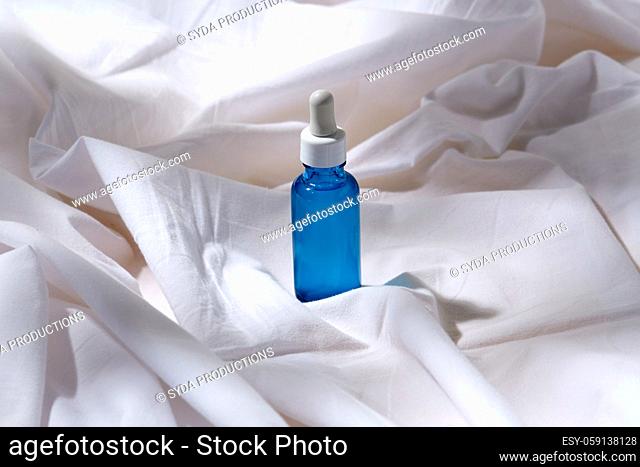 bottle of serum on white sheet