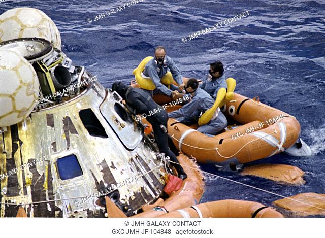 A United States Navy Underwater Demolition Team swimmer assists the Apollo 12 crew during recovery operations in the Pacific Ocean
