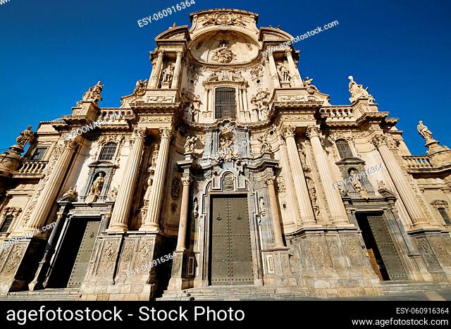 Exterior facade of Cathedral Catholic Church of Saint Mary front view against blue sky background, ancient architecture religious monument in Murcia city, Spain