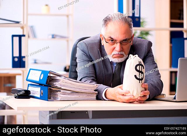 Senior male employee holding moneybag in retirement concept
