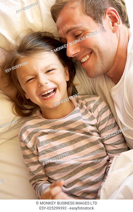 Father And Daughter Relaxing In Bed
