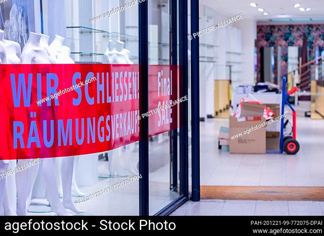 21 December 2020, North Rhine-Westphalia, Münster: ""We're closing - clearance sale!"" is written in an empty shop window on Prinzipalmarkt