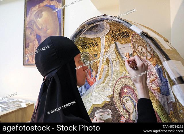 RUSSIA, YEKATERINBURG - DECEMBER 13, 2023: A nun assembles a large Nativity at a mosaic workshop of Alexander Nevsky Novo-Tikhvinsky Convent