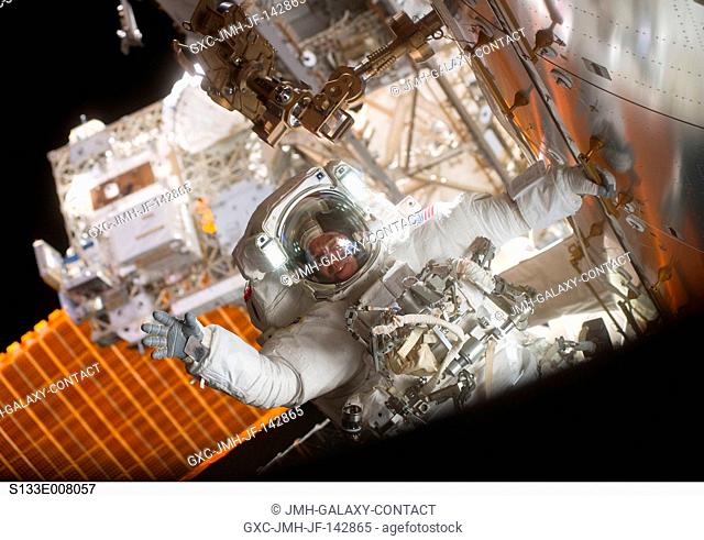 NASA astronaut Steve Bowen (red stripe on suit), STS-133 mission specialist, participates in the mission's second session of extravehicular activity (EVA) as...