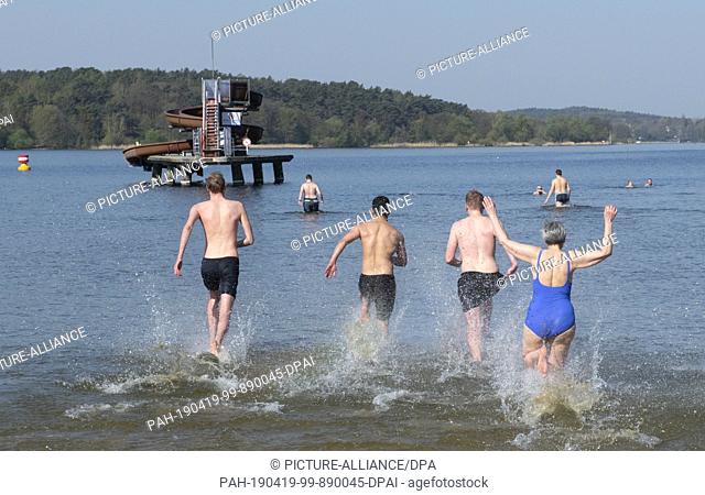 19 April 2019, Berlin: Guests run into the water at the Wannsee lido at the start of the bathing season. The lido always starts the bathing season on Good...