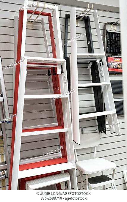 Ladders Displayed on Wall Hooks. Offered for sale in a Manhattan, New York City hardware store